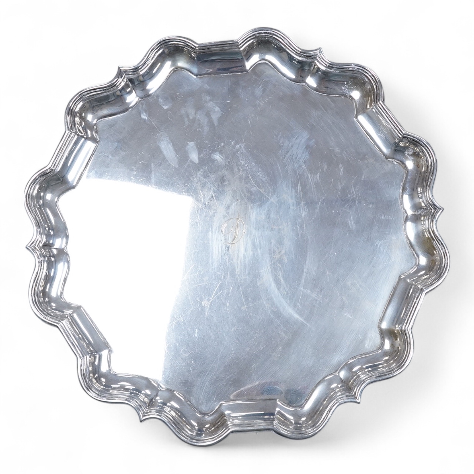 A George V silver salver, by Thomas Bradbury & Sons, of shaped circular form with reeded border and engraved initial, on three scroll feet, Sheffield, 1930, diameter 30.5cm, 33.1oz.